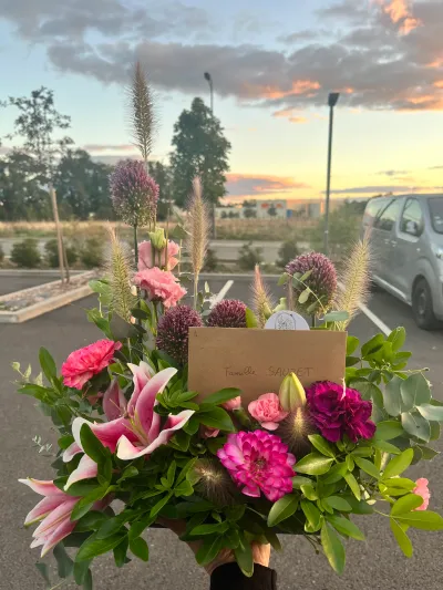 Création de deuil sur mesure, lys roses, dahlias, alliums et graminées dans une caisse, sous un ciel de coucher de soleil