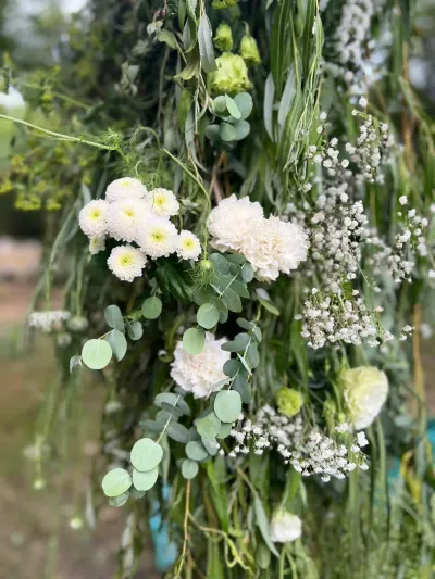 Détail d'une suspension florale de mariage : chrysanthèmes et œillets blancs, eucalyptus et gypsophile