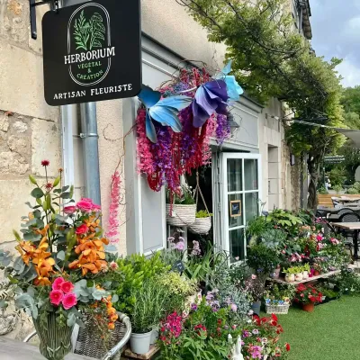 Devanture fleurie de la boutique Herborium à Saint-Benoît, enseigne d'artisan fleuriste et bouquet en vase