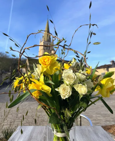 Composition en vase de jonquilles, roses blanches et branches de saule tortueux, face à l'église de Saint-Benoît