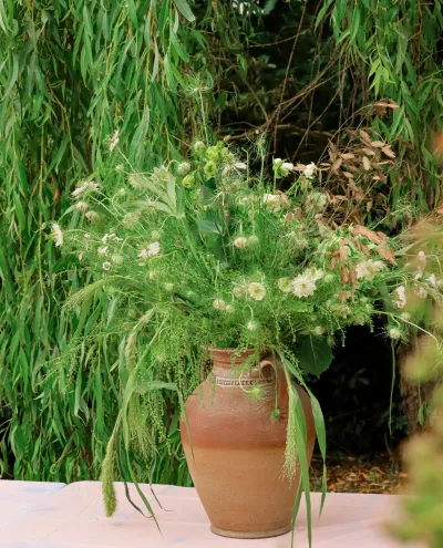 Grand centre de table de mariage en pichet de terre cuite, herbes folles, nigelles et fleurs blanches