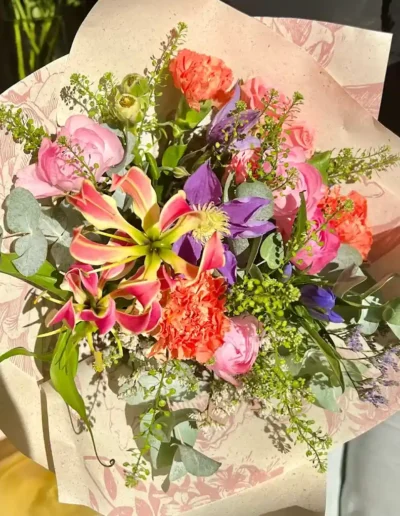 Bouquet printanier aux tons chauds avec des lys, idée cadeau par votre fleuriste local