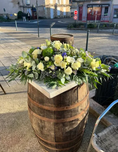 Dessus de cercueil en fleurs naturelles blanches et jaunes, présenté en extérieur dans le centre de Saint-Benoît