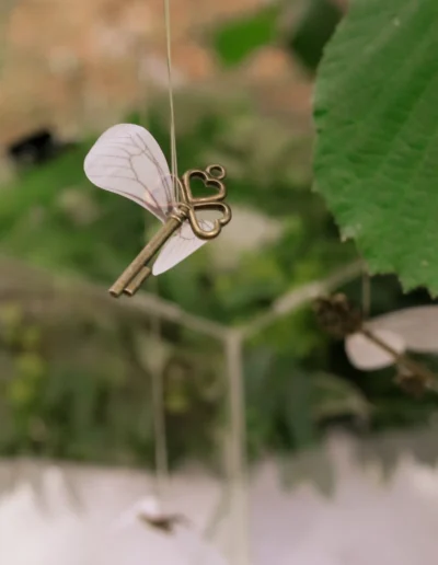 Détail de décoration de mariage poétique avec une clé suspendu au milieu du feuillage
