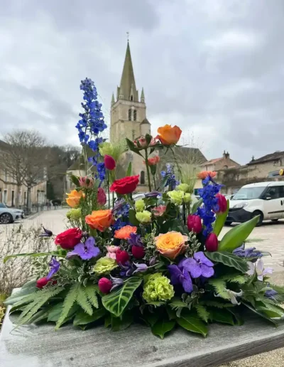Grande composition florale multicolore en hauteur, vue sur le patrimoine de Saint-Benoît (86)