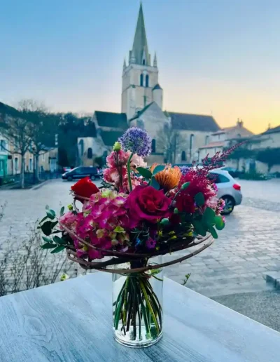 Bouquet de deuil rond tons roses et violets avec hortensias et roses presente dans un contenant stable