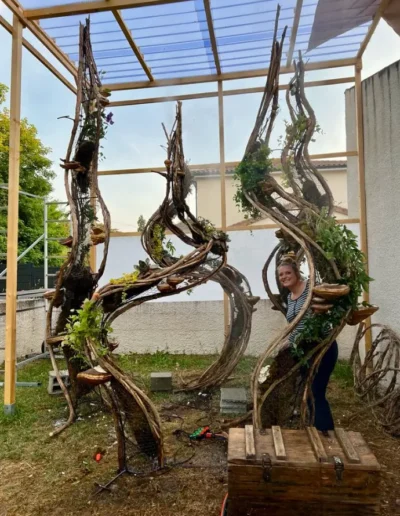 Etape de fabrication de la scenographie vegetale en exterieur sous abri avec Lea Mahe souriante