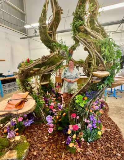 Lea Mahe fleuriste et scenographe vegetale devant son decor entierement fleuri dans son atelier de poitiers